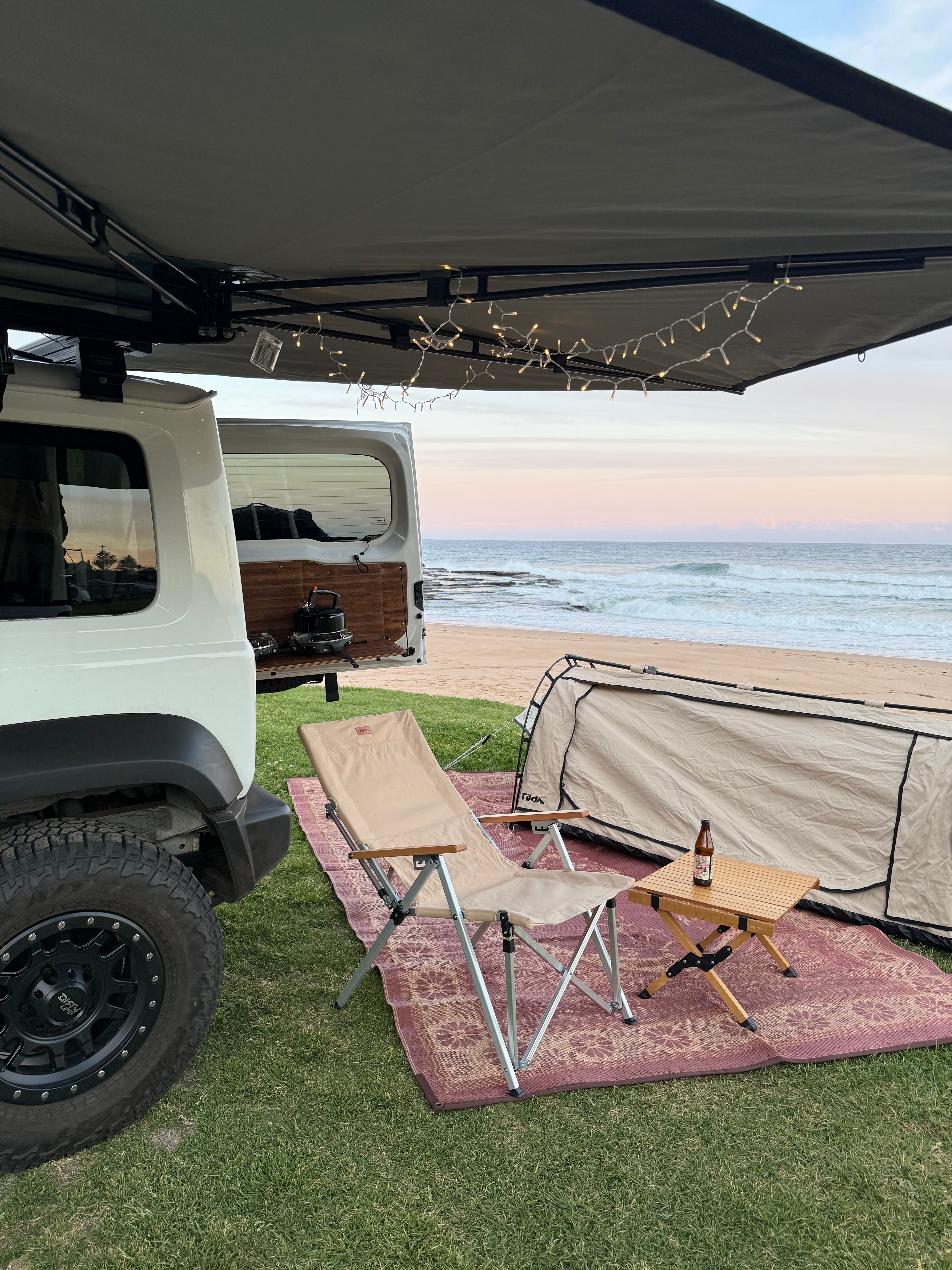 Outdoor camping setup with camping recliner chair and swag next to the beach